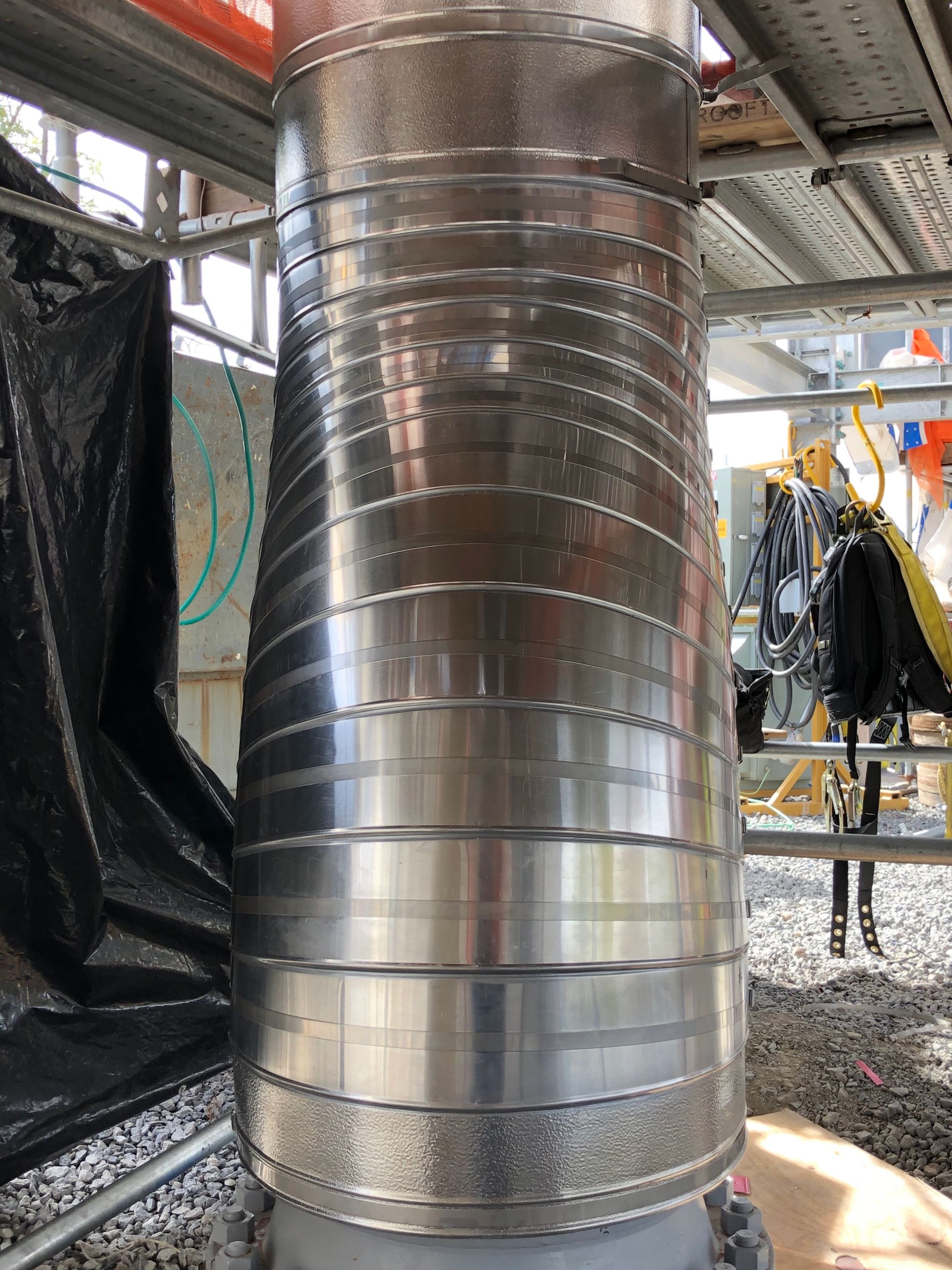 Metal-jacketed vertical riser reducer at an industrial jobsite